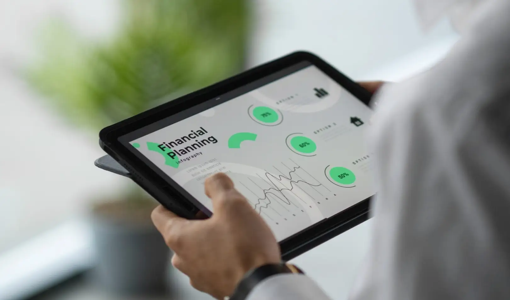 Muškarac drži digitalni tablet na kojem je prikazana infografika za financijsko planiranje